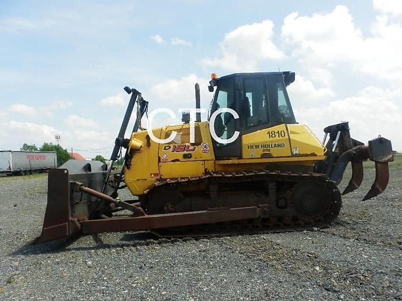 New Holland D180 длина с отвалом — 5487 мм, ширина ходовой части — 2460 мм, высота до верха кабины — 3235 мм.